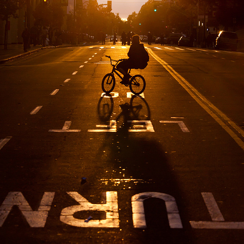 Protestor on Bicycle With Riot Cops in Distance as Sun Begins to Set, Oakland Riots, 2010